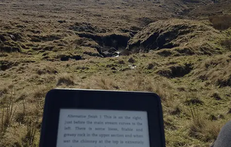 Reading Amazon kindle on hill